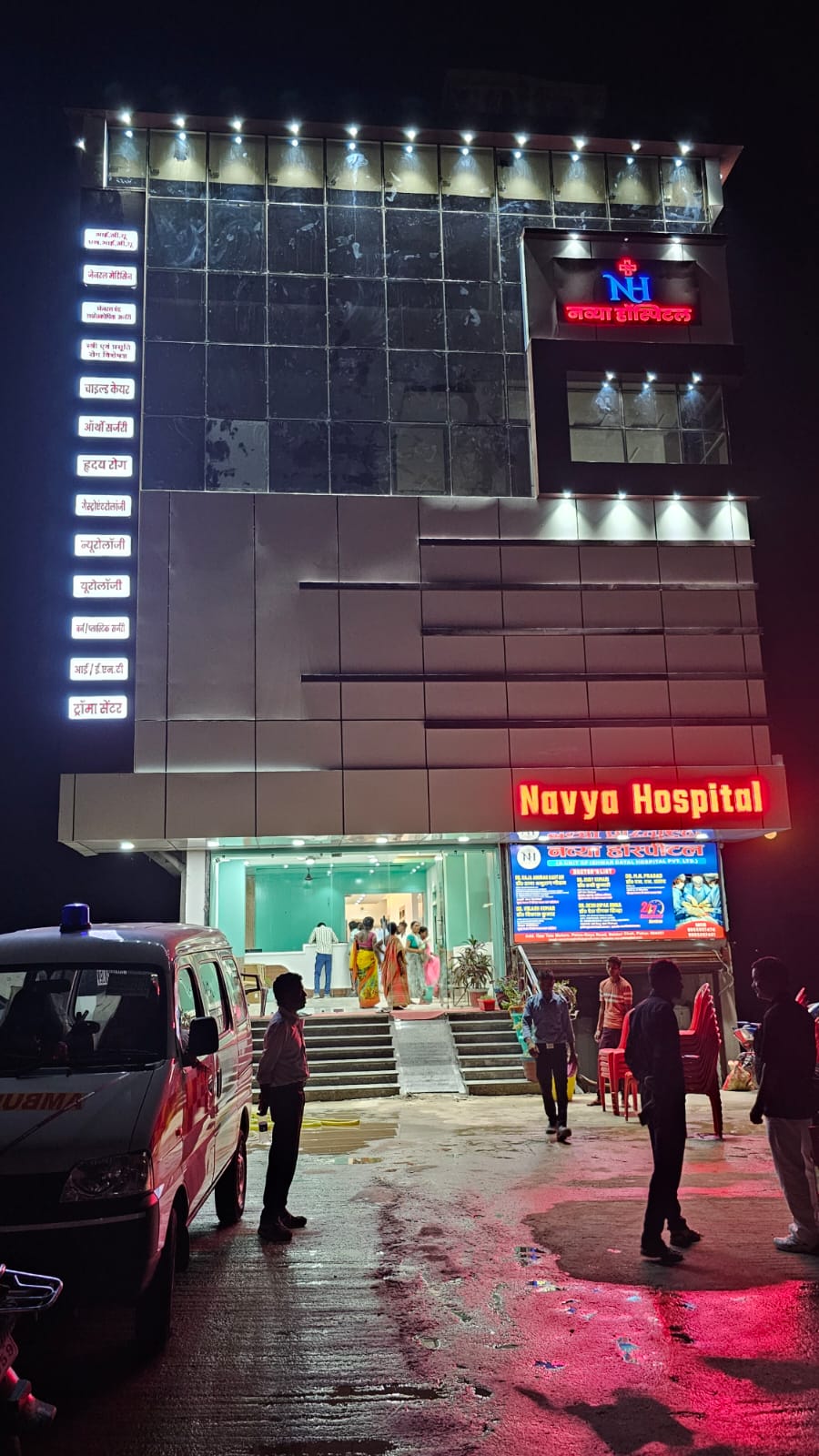 Navya Hospital building illuminated at night with ambulance and neon signage in Patna