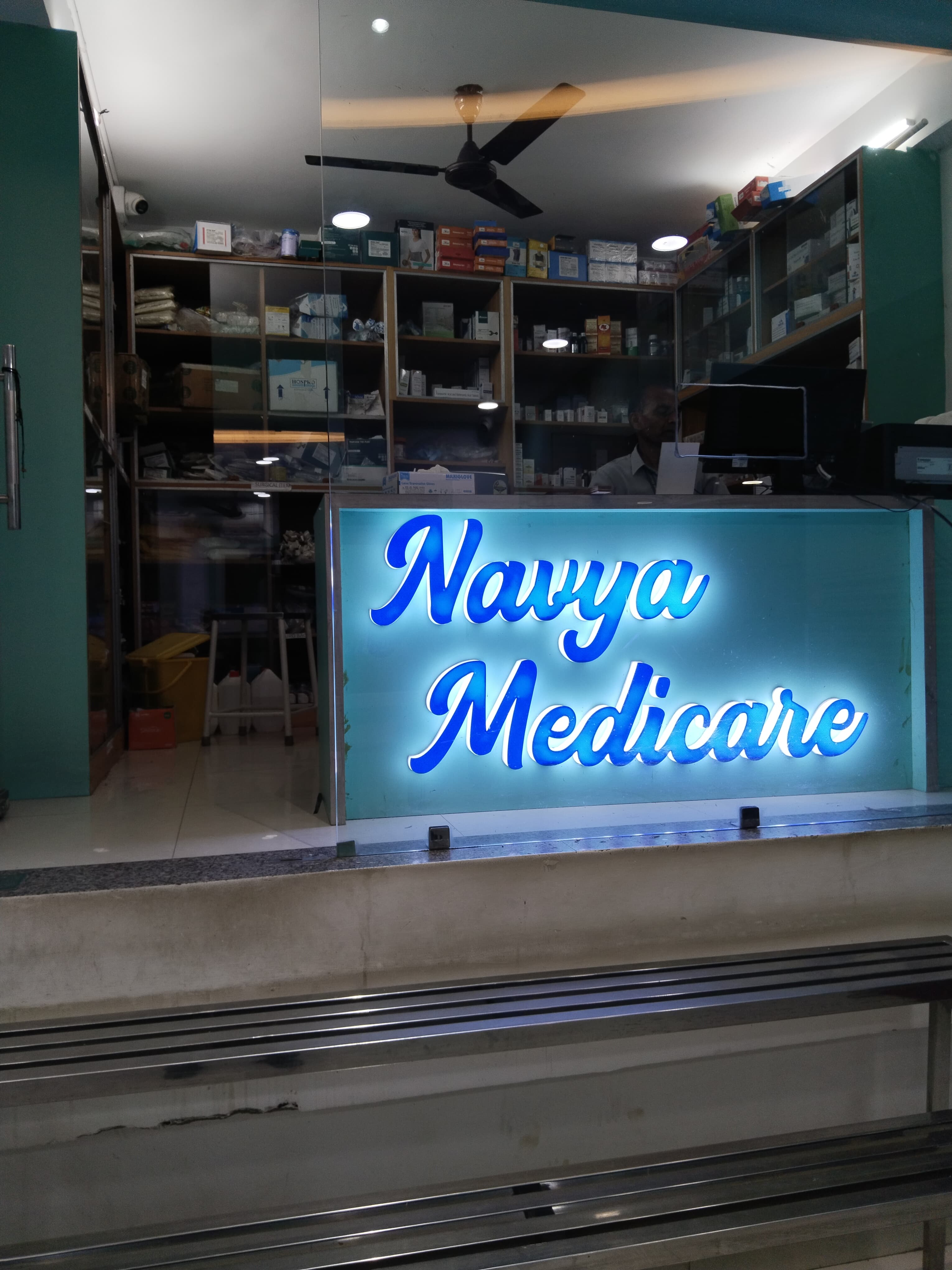 Navya Medicare in-hospital pharmacy counter with medicine shelves and LED signage